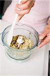 Removing the mixed soya beans and herbs from the food processor with a spatula