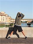Italy, Florence, Man stretching by River Arno