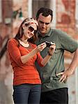 Italy, Venice, Couple viewing digital camera in city