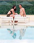 Italie, Portrait de jeune couple de détente au bord de piscine