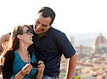 Italy, Florence, Couple viewing camera at lookout over old town