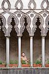 Italy, Ravello, Woman standing on balcony between ornate columns
