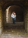 Italy, Ravello, Mature woman piggyback riding on man in stone archway