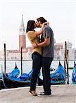 Italy, Venice, Young couple kissing in front of San Giorgio Maggiore Church