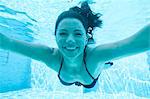 Italy, Amalfi Coast, Ravello, Young smiling woman swimming underwater, front view