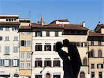 Italy, Florence, Silhouette of young couple kissing against row of buildings