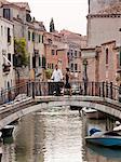Italy, Venice, Romantic couple walking on footbridge over canal