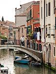 Italy, Venice, Romantic couple walking on footbridge over canal