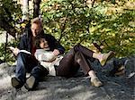 États-Unis, New York City, Manhattan, Central Park, couple d'âge mûr lecture livre à Central Park