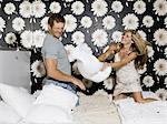 young couple having a pillow fight