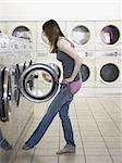 woman taking off her clothes at the laundromat