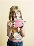 little girl putting money in her pink wallet