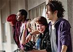 Young attractive teen punk looks towards the camera while her group of friends look away.