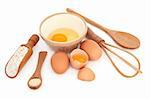 Natural baking ingredients of egg, yeast and brown wholegrain flour with wooden cooking utensils over white background.