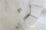 White toilet bowl in a bathroom with white marble tiles