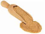 Demerara brown sugar in a wooden scoop over white background.