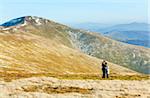 Family (mother with son) walk and make photo on autumn  mountain plateau