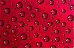 Water drops on glass texture over red background