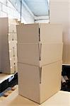 A lot of various cardboard boxes arranged up in stacks at an industrial distribution storage room