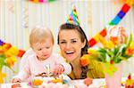 Portrait of mother and baby with birthday cake