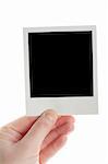 One instant photo in hand isolated on white background