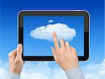 Man hand holding tablet pc and touch the cloud against blue sky with clouds. Concept image on cloud computing theme.