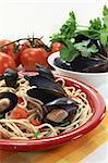 a plate of spaghetti, mussels and tomato