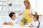 Healthy breakfast for happy life - mother serving kids with salad