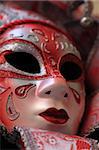Closeup image of a red Venetian mask.