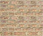 weathered brick wall with various shades of brick. Rough mortar is visible.