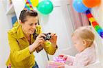 Mother making photos at babies birthday party