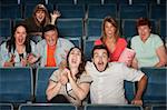 Group of seven scared people screaming in a theater