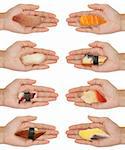 8 hands holding out various kinds of sushi/sashimi isolated on white.