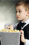 Kleiner Junge mit Popcorn auf schwarzem Hintergrund