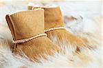 Pair of brown winter boots on fox fur background