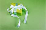 Gift box with ribbon on green background