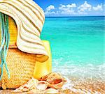 Beach items over blue sea conceptual image of summertime vacation & holidays