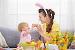 Mother and baby knocking Easter eggs