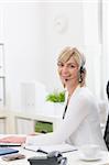 Happy middle age business woman with headset working at office