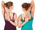 Two fit women stretching their arms over white background
