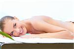 Smiling woman taking spa treatment with hot stones