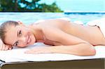 Beautiful woman lying on spa bed at exotic outdoor