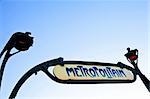 Traditional entrance sign of metro station in Paris. Clean sky in background, copy space