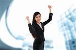 Excited business woman celebrating success, modern building as background.