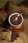 Wooden grinder with coffee beans on the tree with a bag