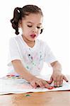 Stock image of child finger painting with watercolors over white background