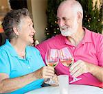 Senior couple at a cafe, enjoying a glass of white wine together.