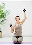 Young woman lifting dumb-bells