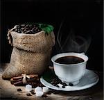 Coffee concept with coffee beans and fresh coffee leaves