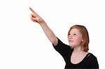 Girl points with her finger up on white background